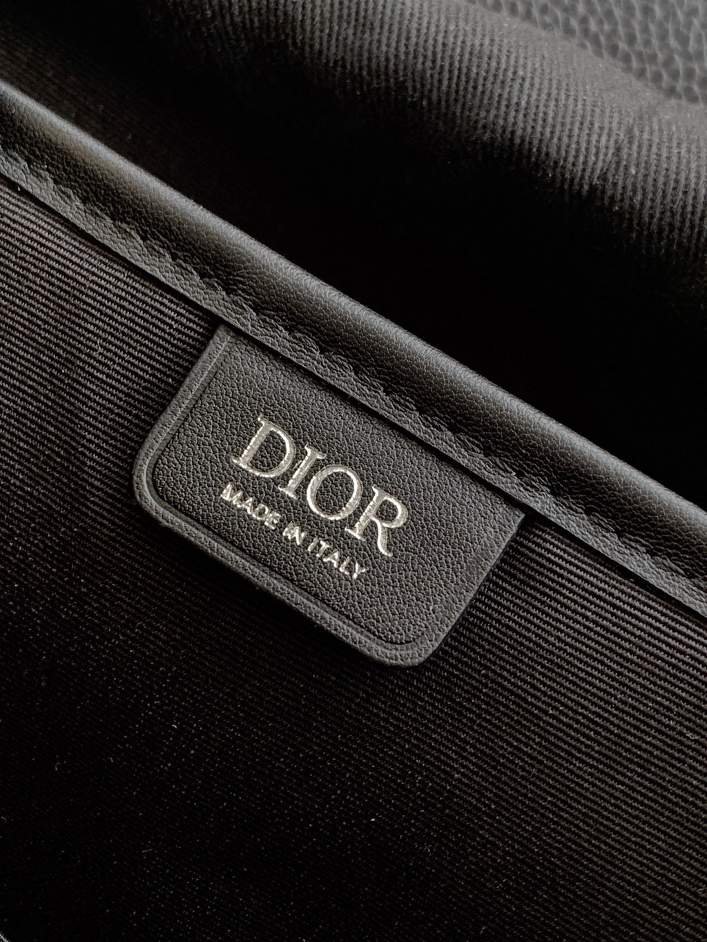 Dior backpack bag interior label with Dior text and Made in Italy