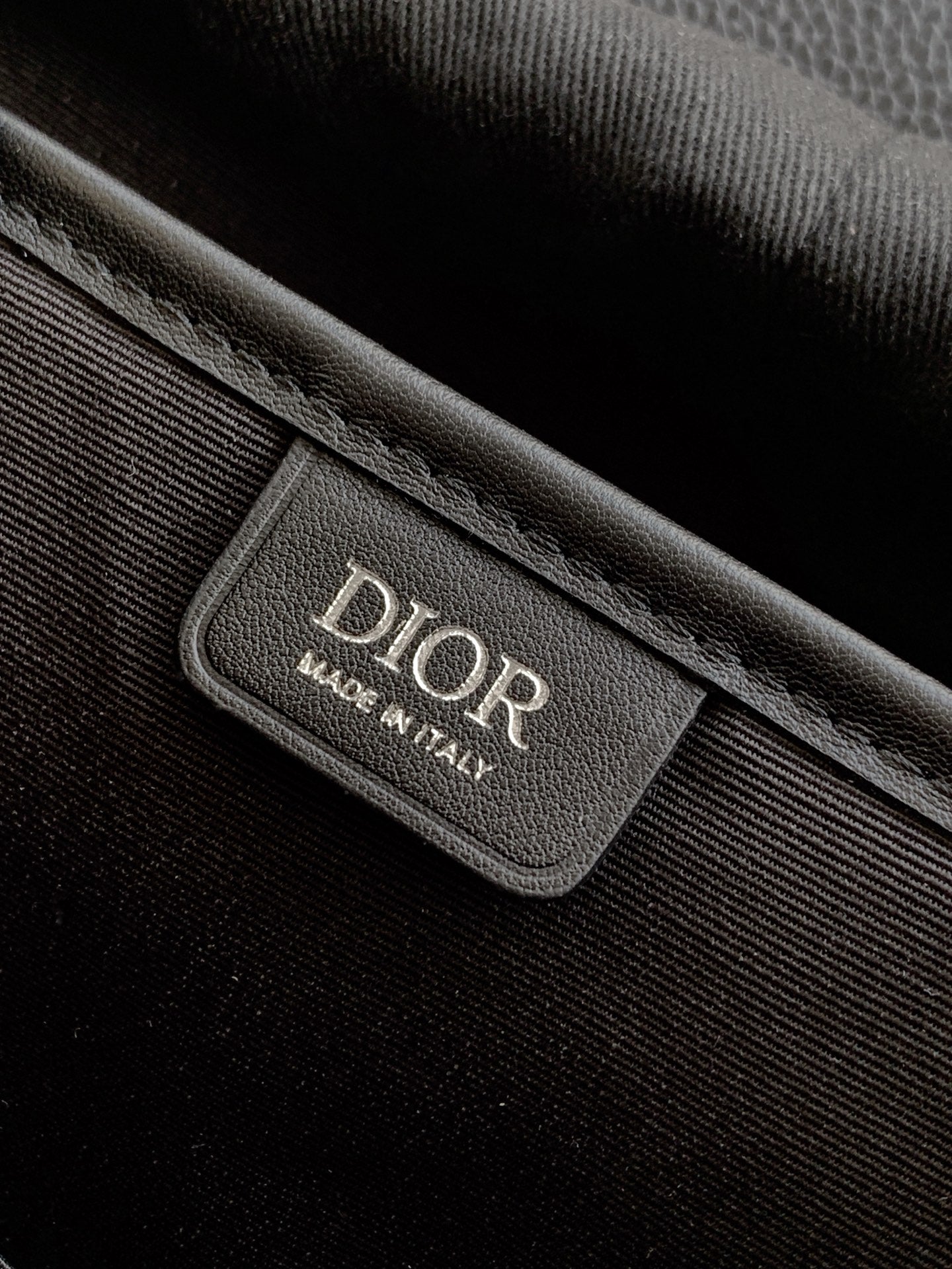 Dior backpack bag interior label with Dior text and Made in Italy