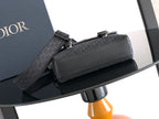 Dior bag with front flap and detachable strap, black textured leather with metal clasps.