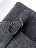 Dior bag close-up of dark gray fabric strap with gray buckle and leather trim edge.