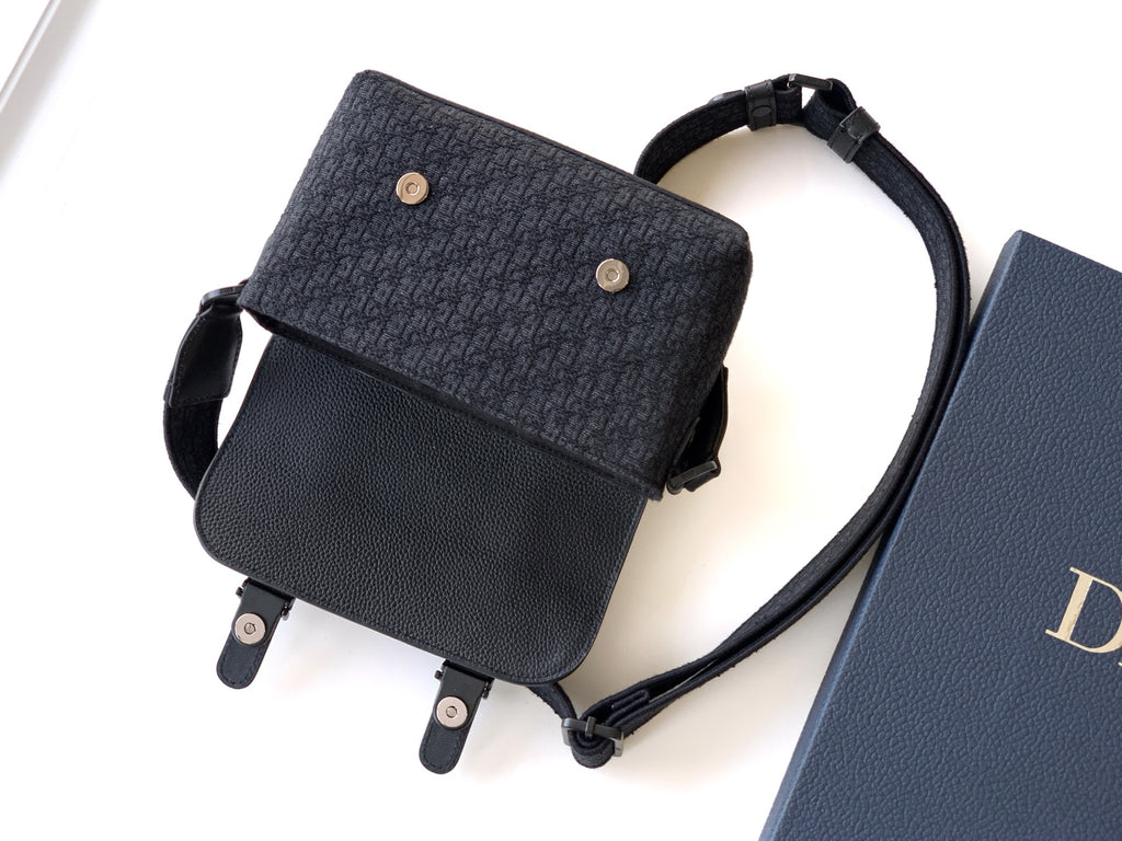 Dior crossbody bag with adjustable strap, dark textured body and gold snap buttons