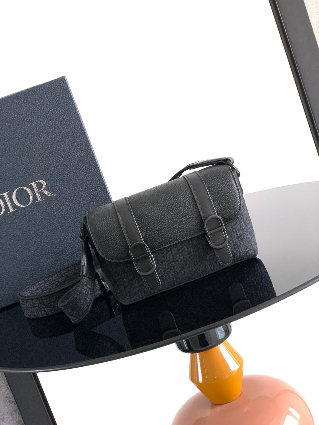 Dior bag crossbody with textured black exterior, front flap and buckle closure.