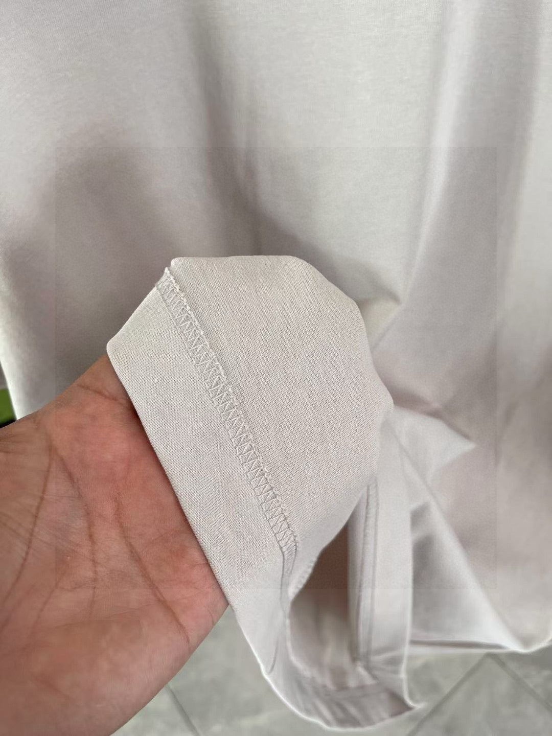 Louis Vuitton light gray T-shirt fabric close-up with side seam stitching