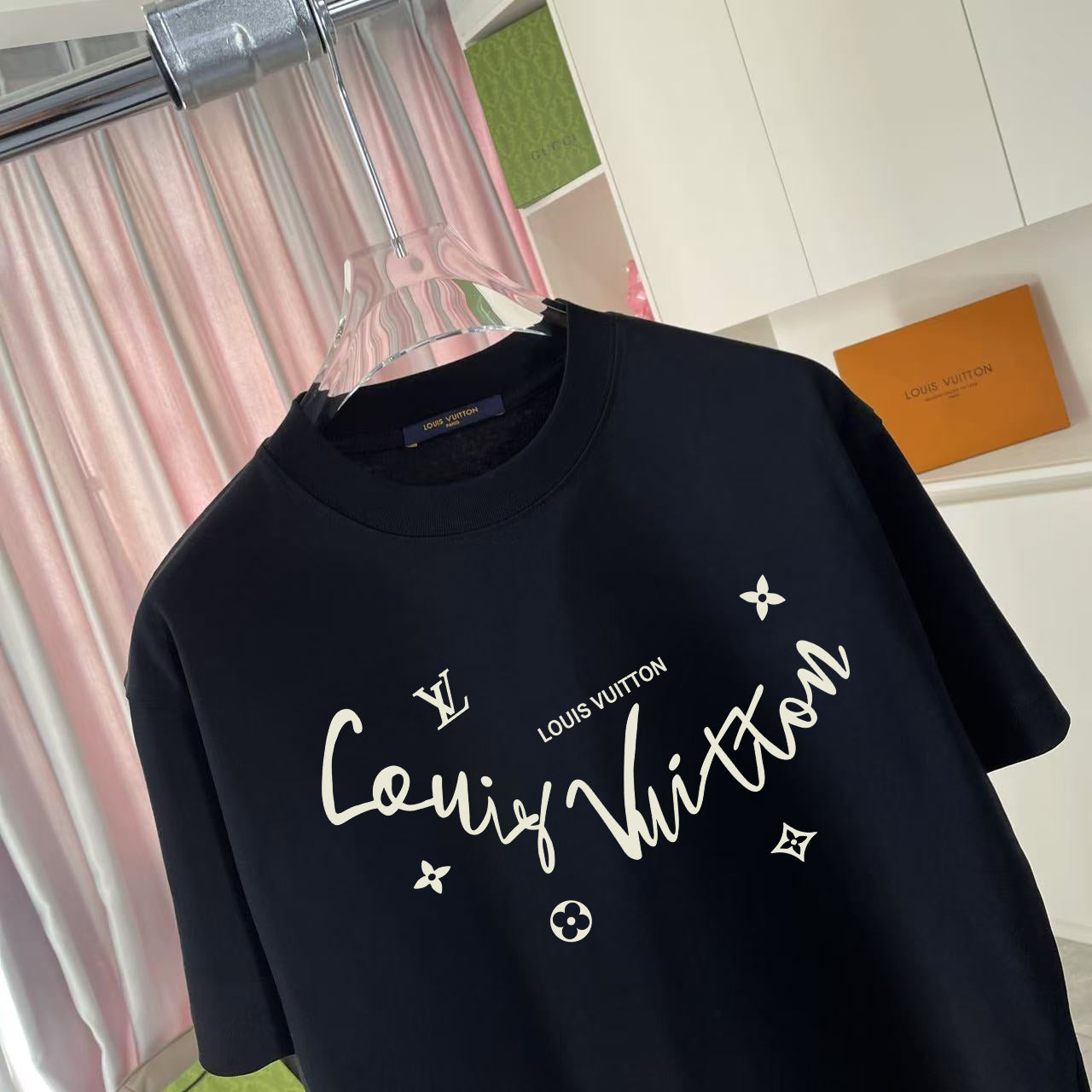Louis Vuitton T-shirt, black, close-up of gold script logo with star and flower icons