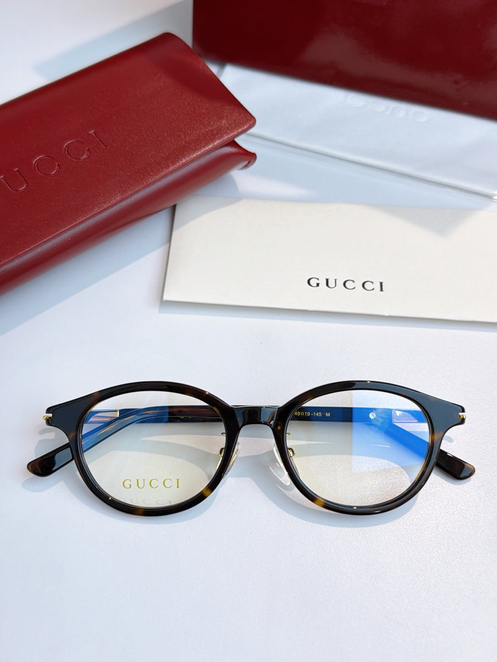 Gucci eyeglasses with black round frames and blue-tinted lenses, front view