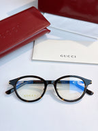 Gucci eyeglasses with black round frames and blue-tinted lenses, front view