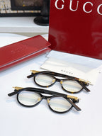 Gucci eyeglasses, two black round pairs with blue-tinted lenses; gold logo temples