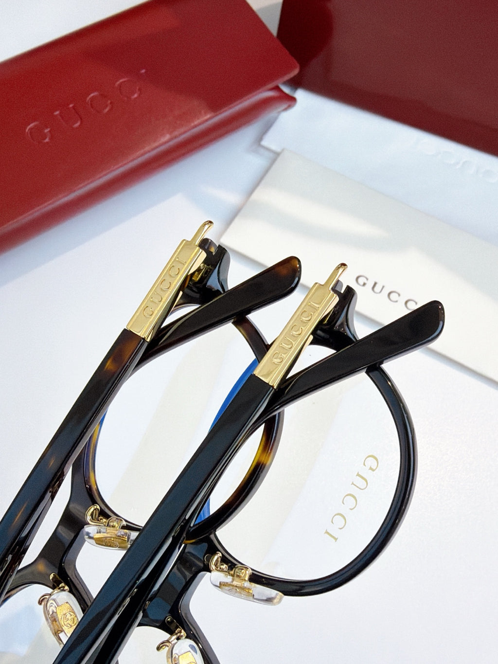 Gucci eyeglasses, black round frames with gold temple hardware; blue lens tint