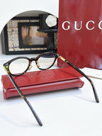 Gucci eyeglasses, black frames with blue lens tint; angled side view