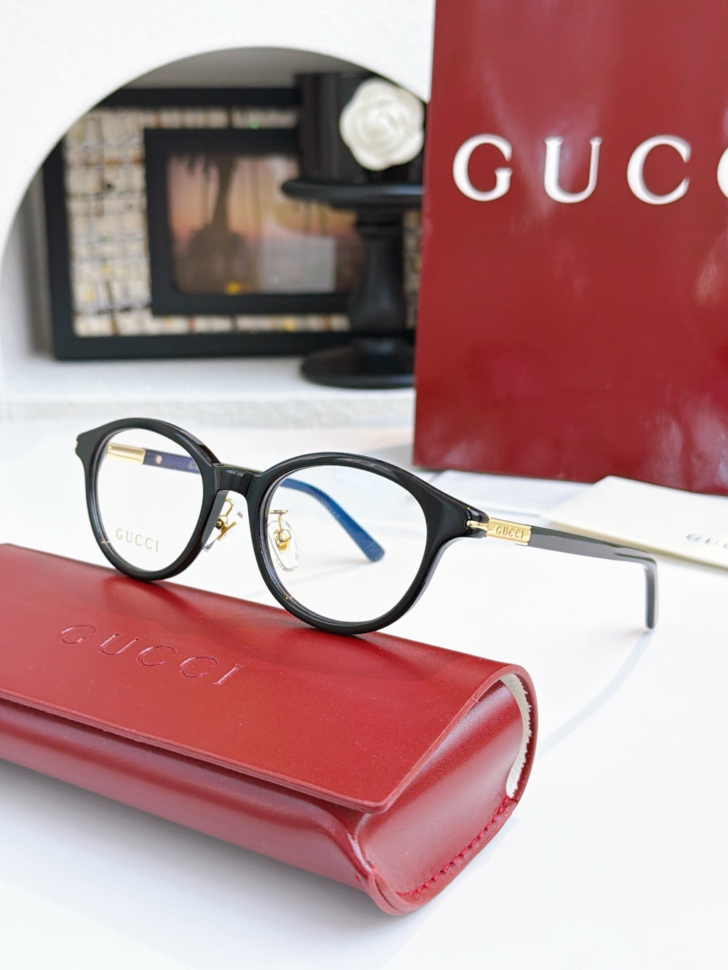 Gucci eyeglasses, black frames with blue lens tint; gold logo on temple