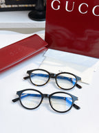 Gucci eyeglasses, black round frames with blue-tinted lenses; two pairs shown
