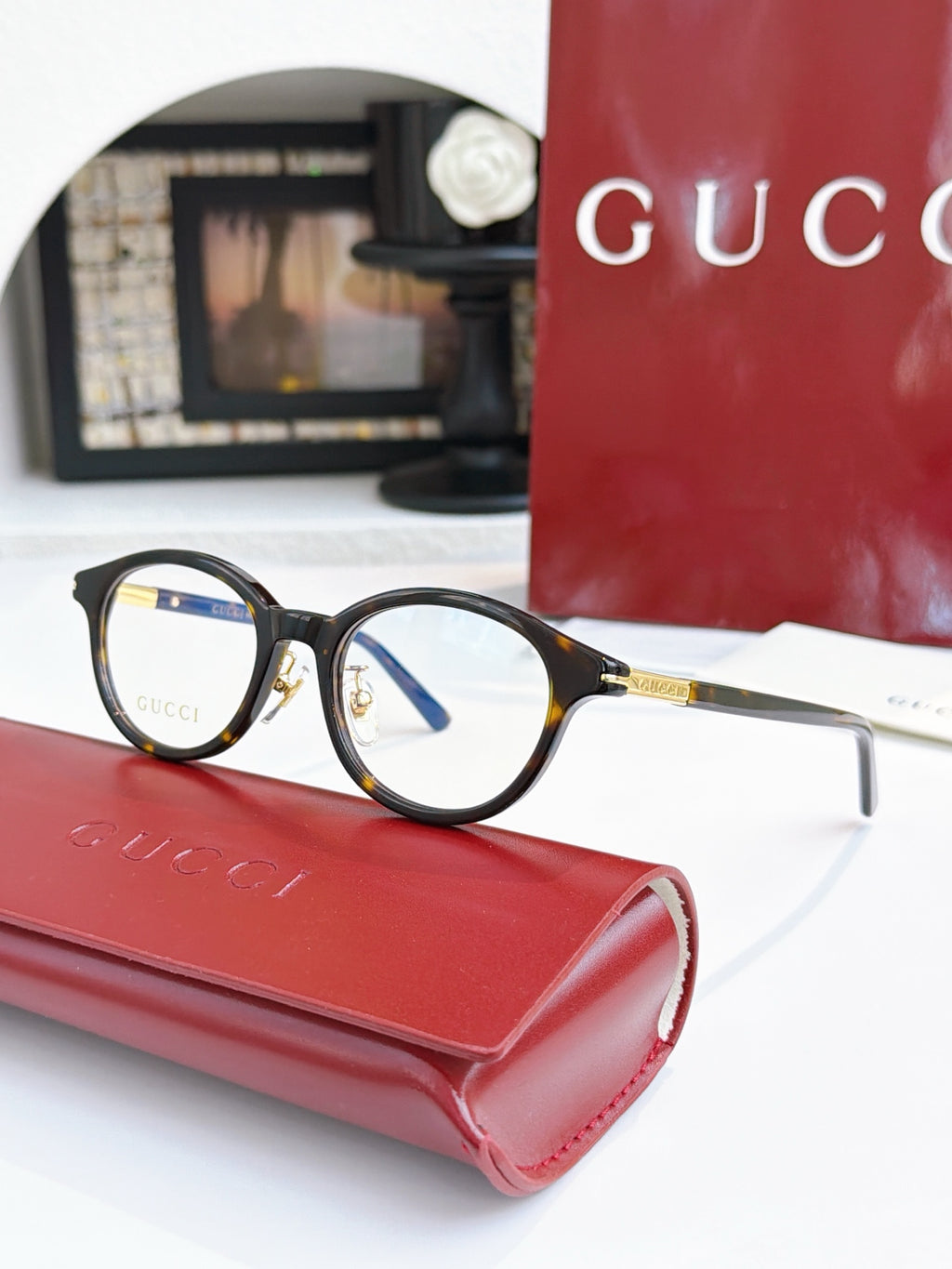 Gucci eyeglasses, black round frames with blue lens tint; gold temple details