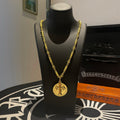 Gold-tone cross pendant necklace with chain, shown on black jewelry bust.