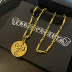 Gold-tone cross pendant necklace and chain on black box, two necklaces displayed.