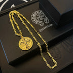 Gold-tone cross pendant necklace and chain on black gift tray, multiple pieces.