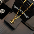 Gold-tone anchor pendant necklace on black gift box