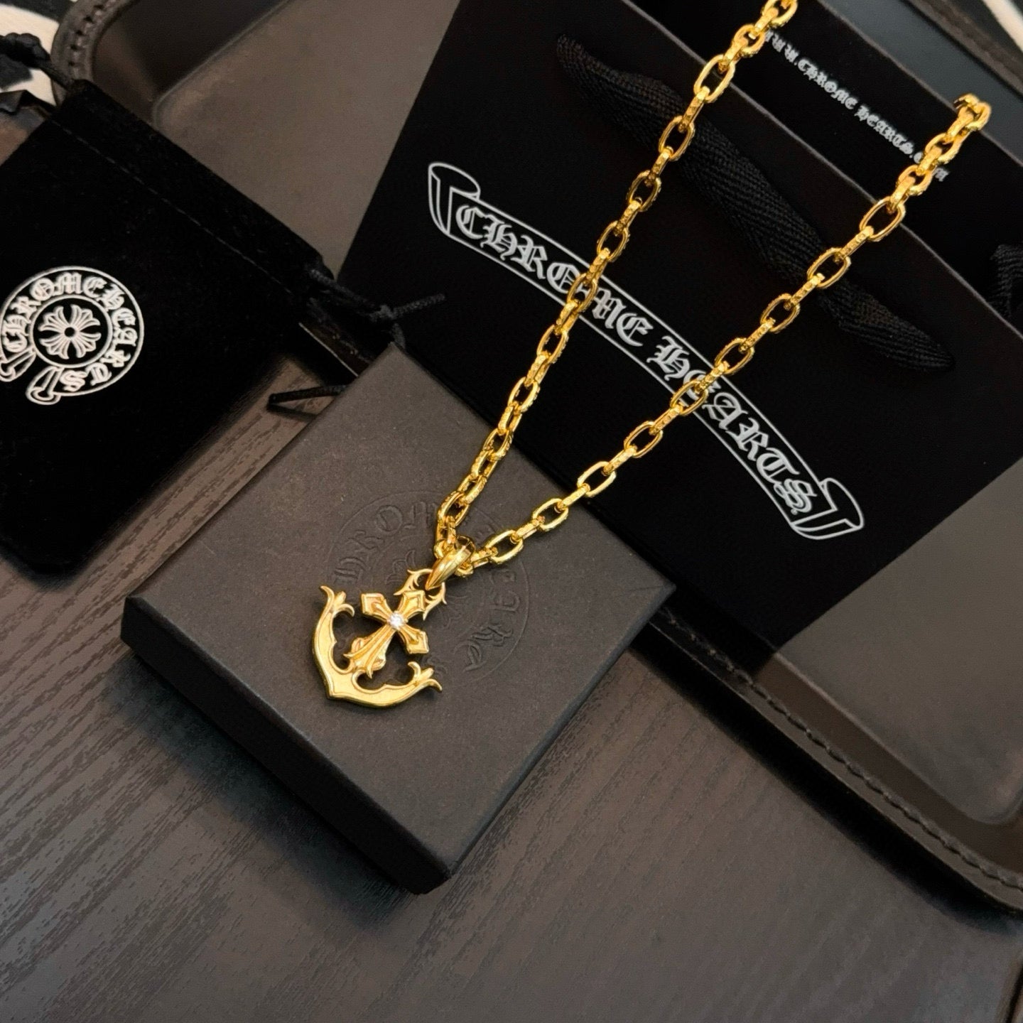 Gold-tone anchor pendant necklace on black gift box
