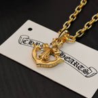 Gold-tone crown and anchor pendant necklace on white product tag