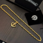 Gold-tone anchor pendant necklace with curb-link chain, laid flat