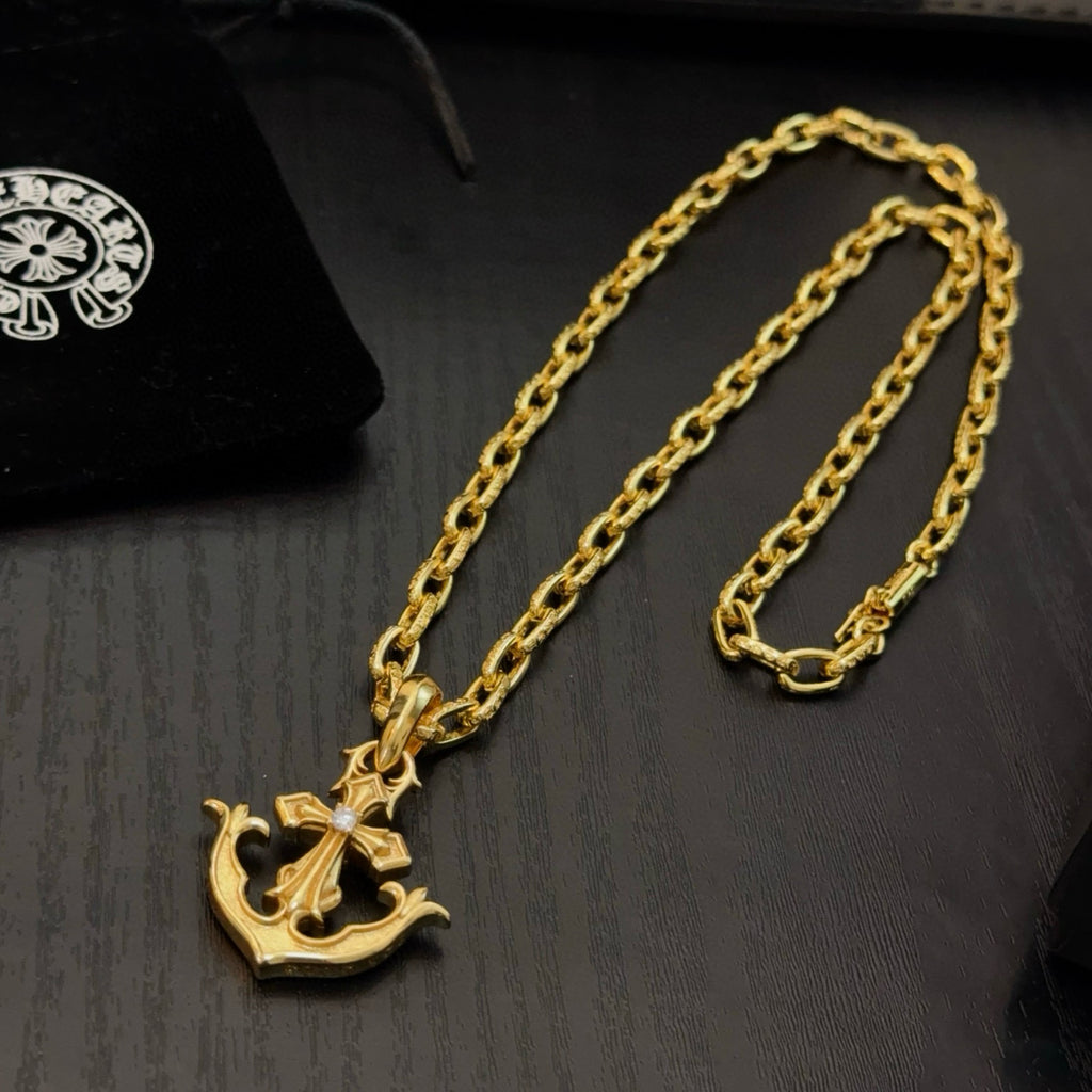 Gold-tone anchor pendant necklace with curb-link chain on stand