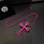 Pink beaded cross necklace with floral cross pendant, laid on a dark surface