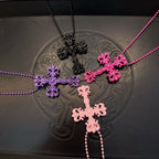 Layered bead necklaces with cross pendants in pink, purple, and black tones