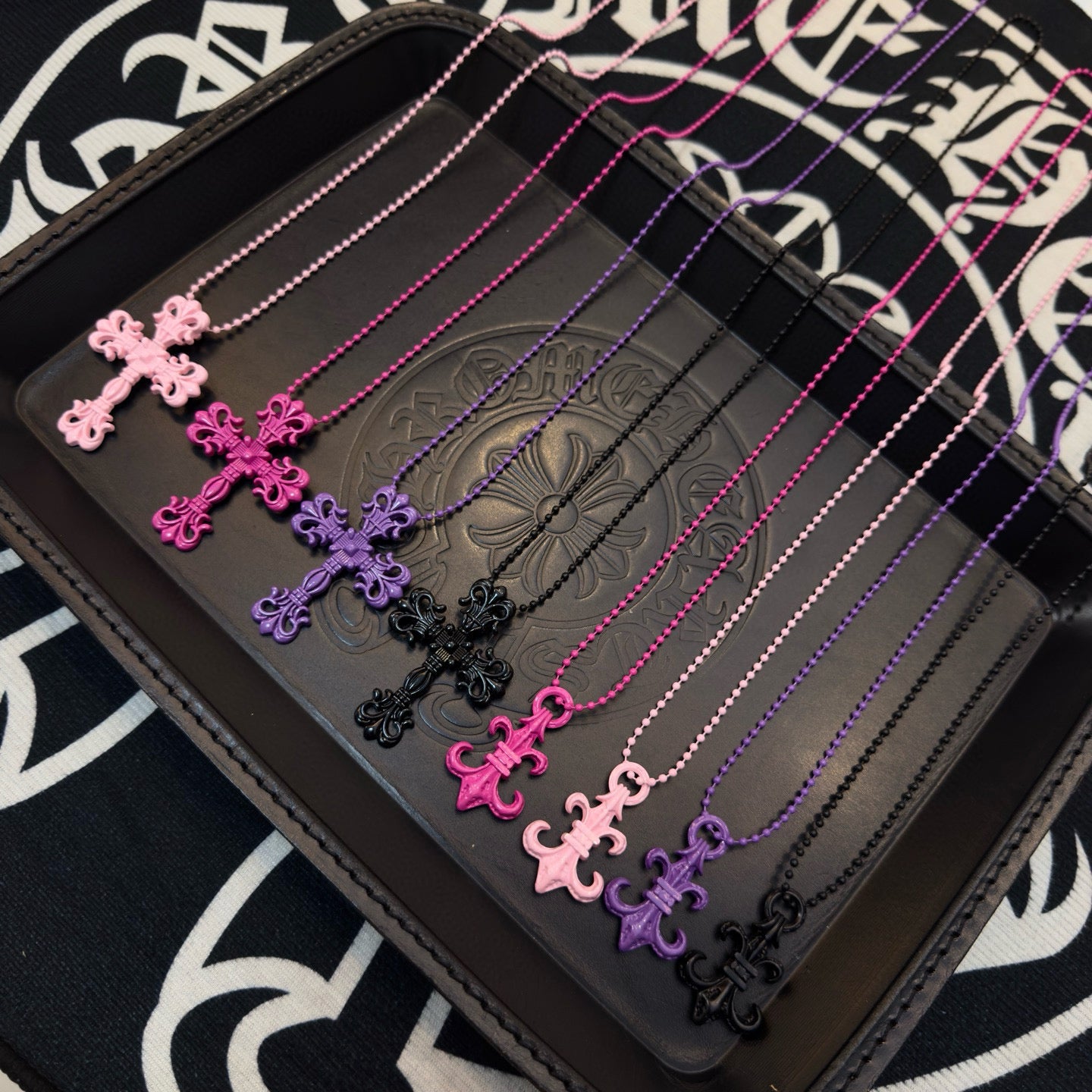 Ornate cross necklace with pink bead chain and magenta floral cross pendant