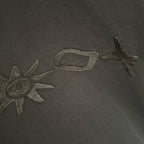 Embroidered graphic on black T-shirt with star and abstract shapes.