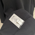 Black T-shirt care label on inner sleeve seam.