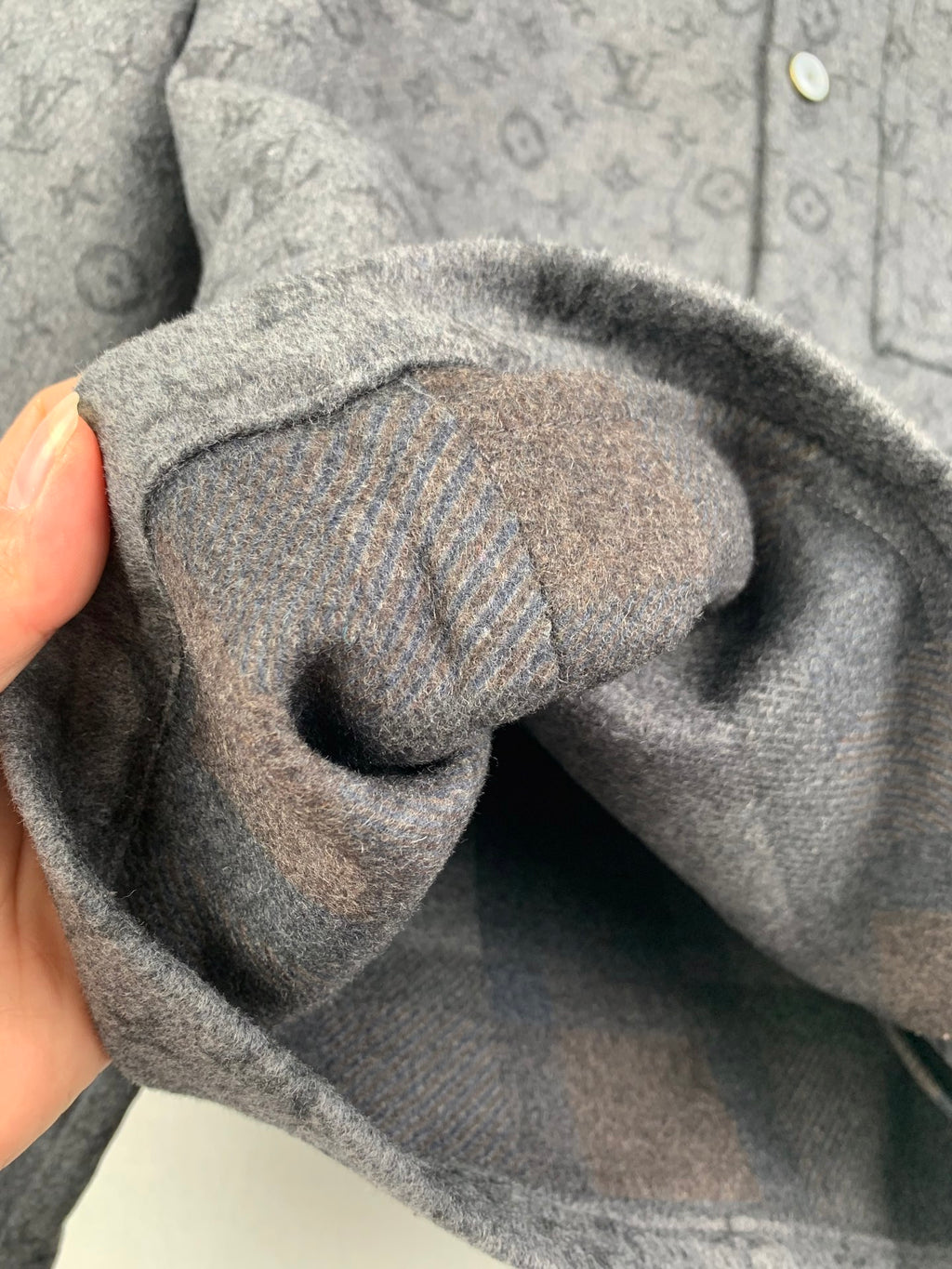 Monogram button-up shirt sleeve cuff close-up with folded fabric
