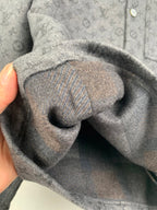 Monogram button-up shirt sleeve cuff close-up with folded fabric