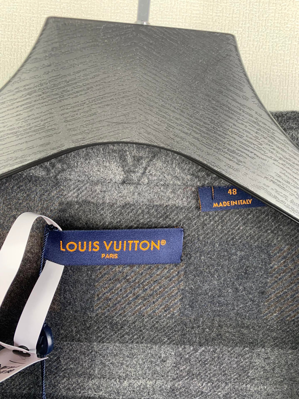 Louis Vuitton logo label and size tag on grey long-sleeve jacket