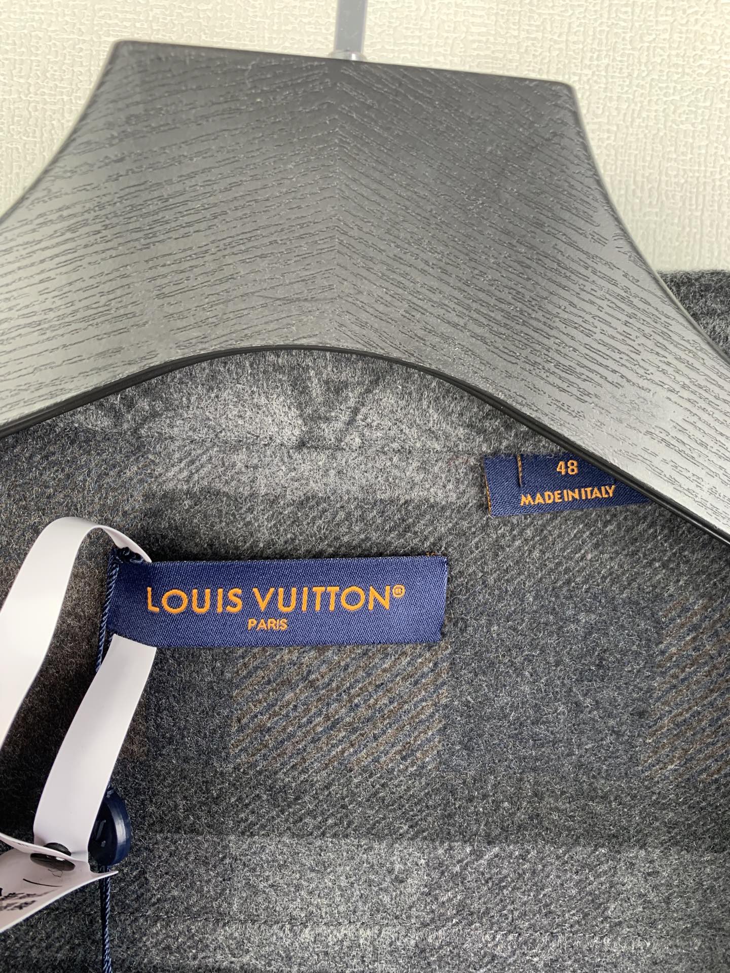 Louis Vuitton logo label and size tag on grey long-sleeve jacket