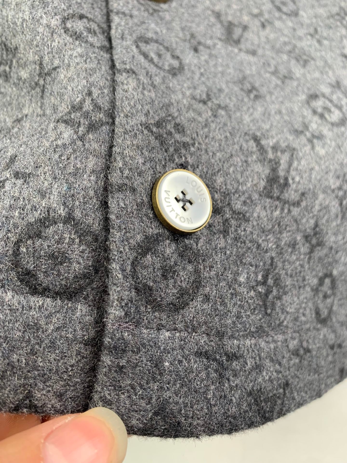 Monogram button-up shirt close-up of gold-trimmed snap button on pocket area