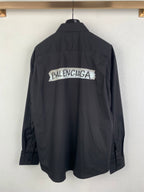 Long-sleeve button-up shirt, dark gray, back view with large logo print