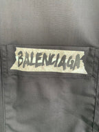 Long-sleeve button-up shirt, gray, close-up of front logo patch