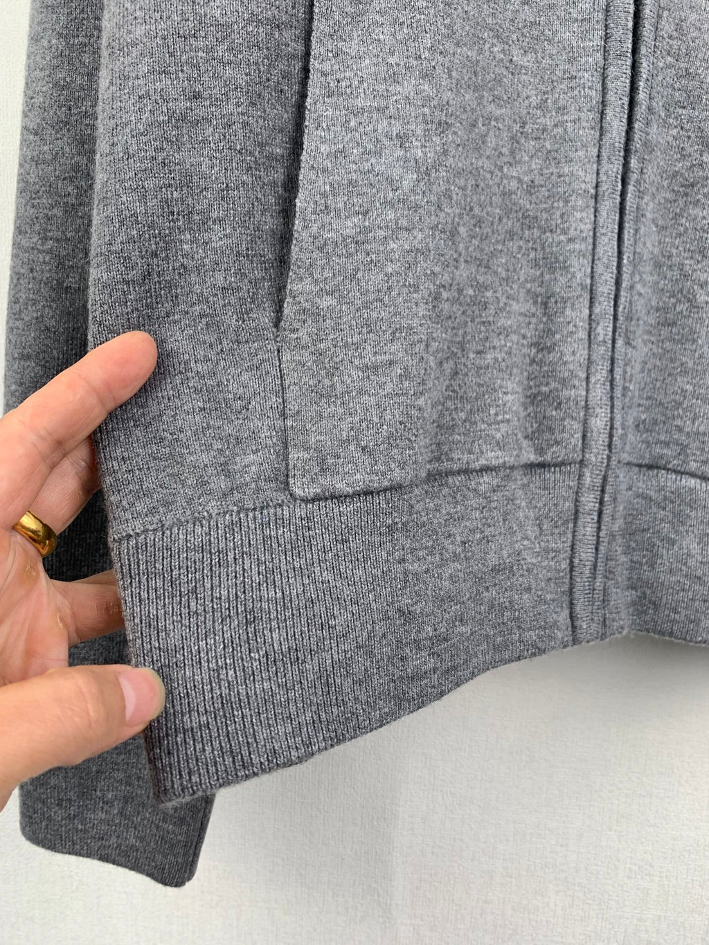 Gray hoodie hem and pocket area with ribbed bottom cuff