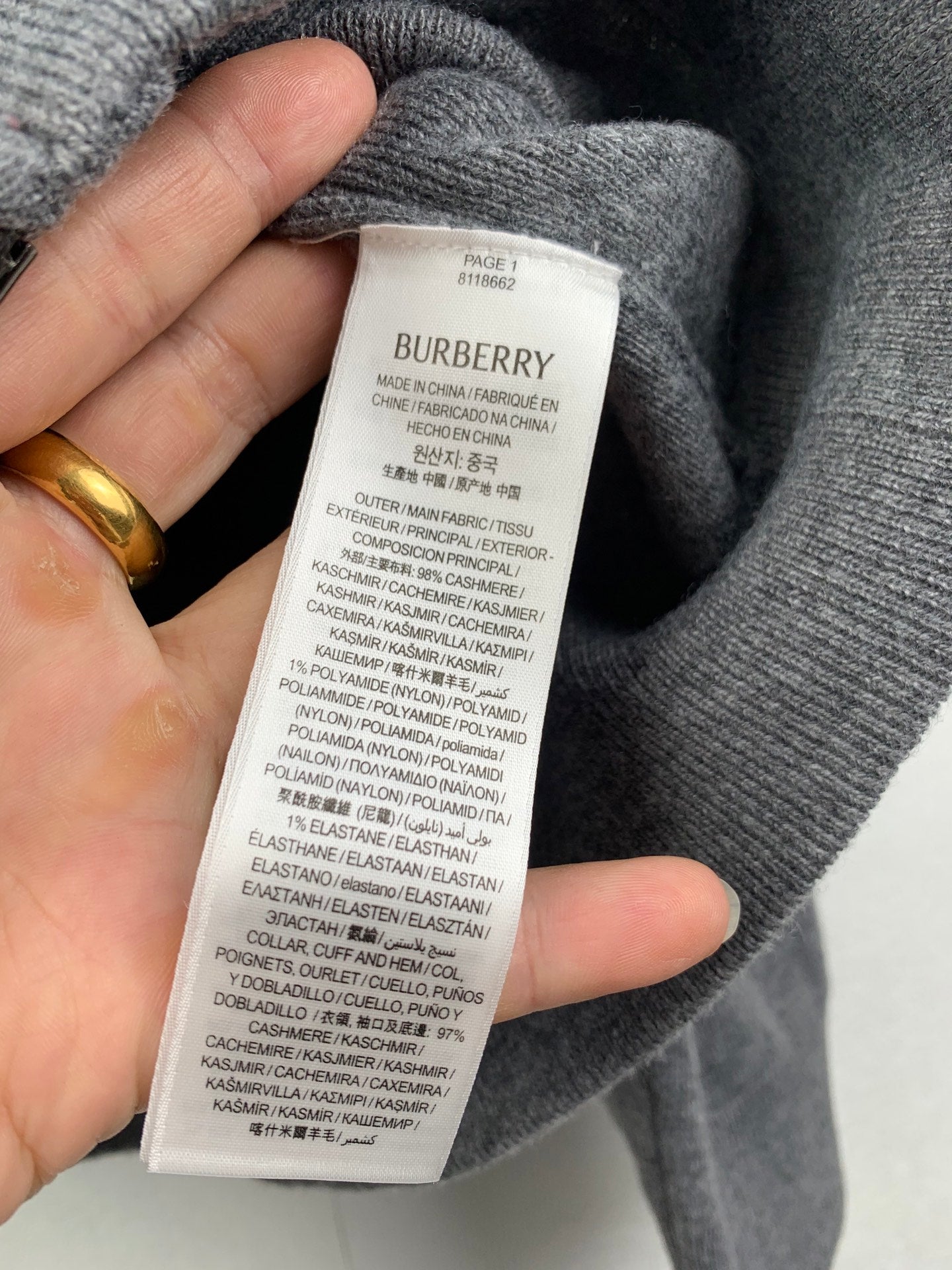 Gray hoodie fabric tag with size and material composition text