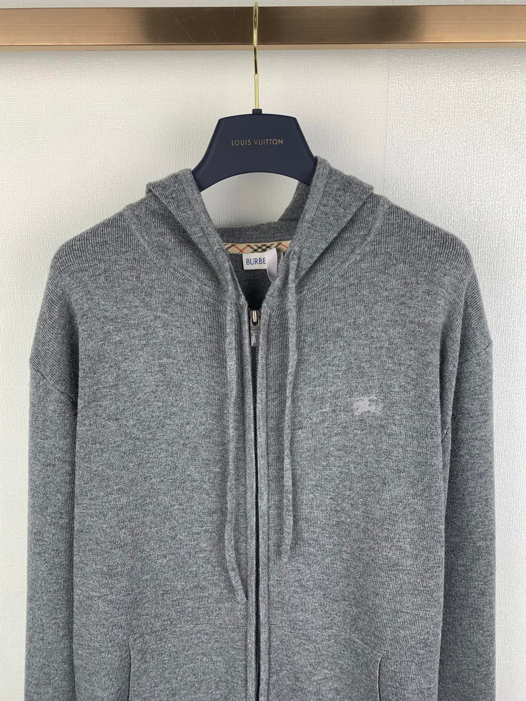 Gray zip-up hoodie with drawstring hood and small chest logo