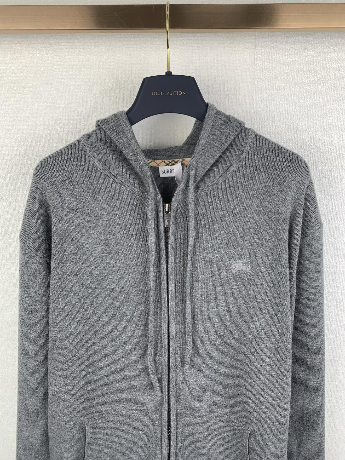 Gray zip-up hoodie with drawstring hood and small chest logo