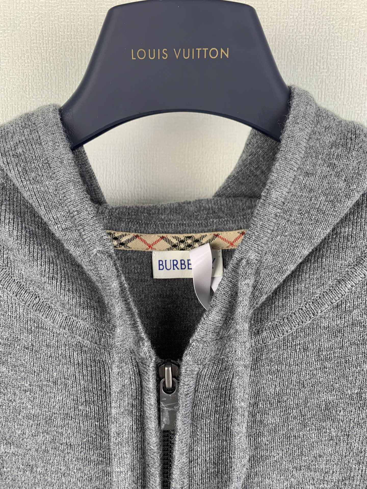 Gray hoodie neckline with inner hood label and metal zipper pull