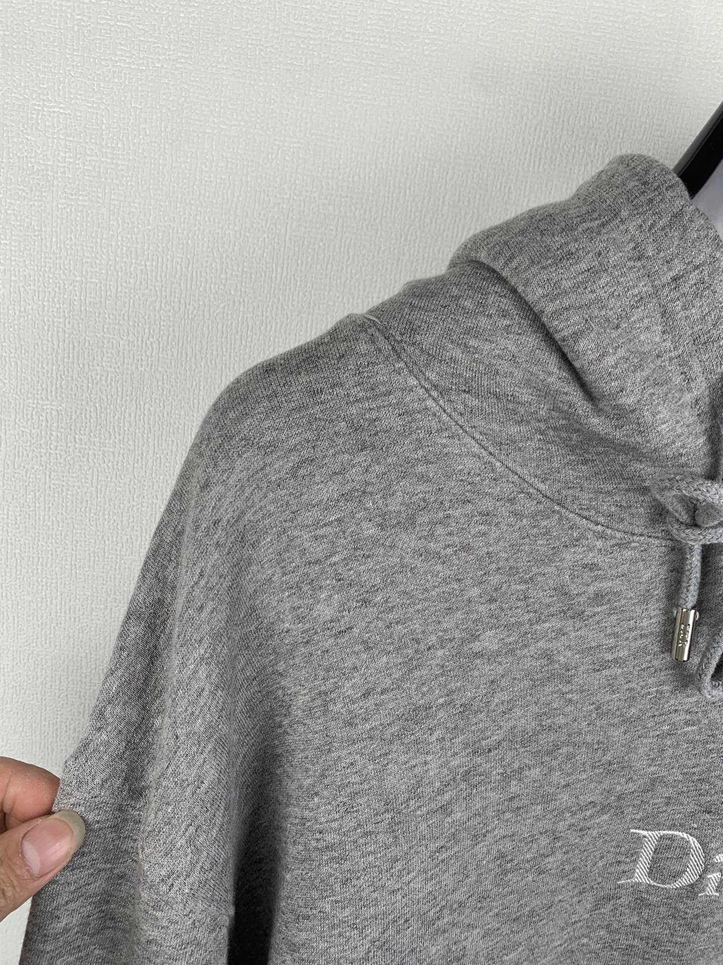 Gray hoodie hood and sleeve with drawstring cord detail