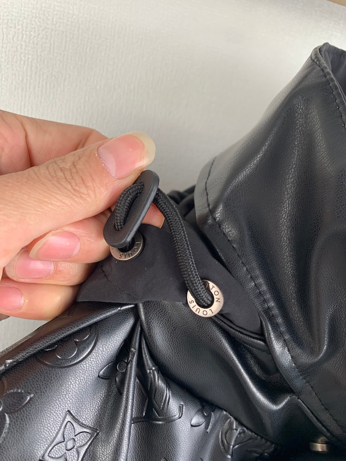 Louis Vuitton jacket collar with button closure and strap near logo pull tab