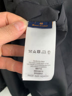 Clothing care label tag showing size 48 and Louis Vuitton, RM261 AUR HQN83V