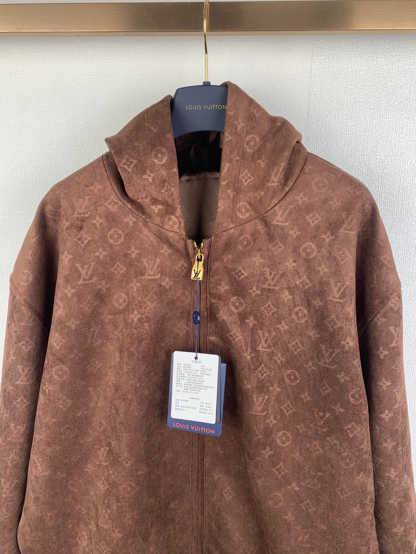 Dark brown monogram zip-up hooded jacket with gold-tone front zipper and hang tag