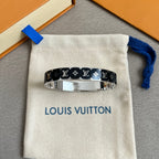 Louis Vuitton black monogram bangle with silver face on cream pouch, close-up