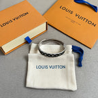 Louis Vuitton black monogram bangle with silver interior, on cream pouch with blue ribbon