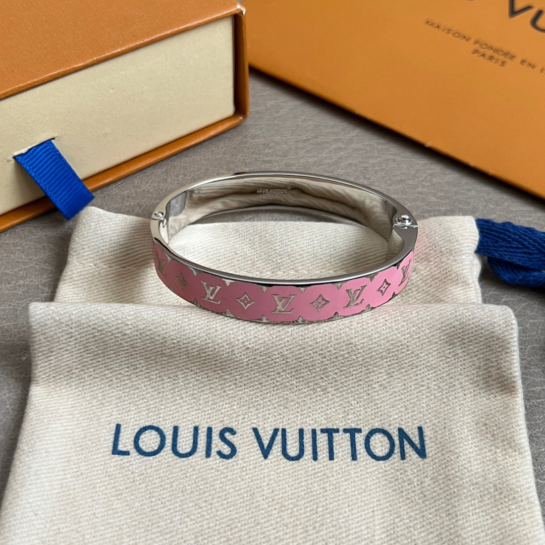 Pink monogram bangle bracelet with silver-tone metal cuff, on a white dust bag