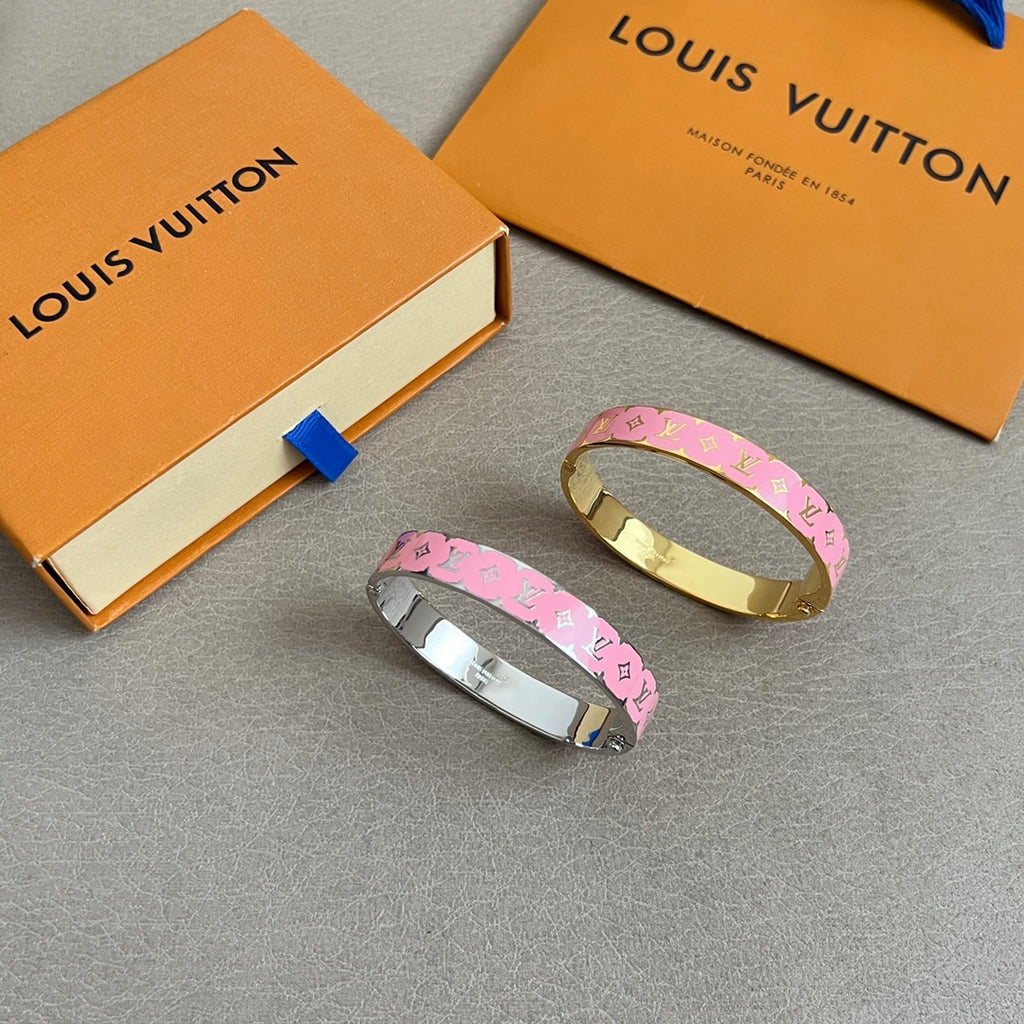 Pair of monogram bangle bracelets: one silver-tone, one gold-tone, pink logo band