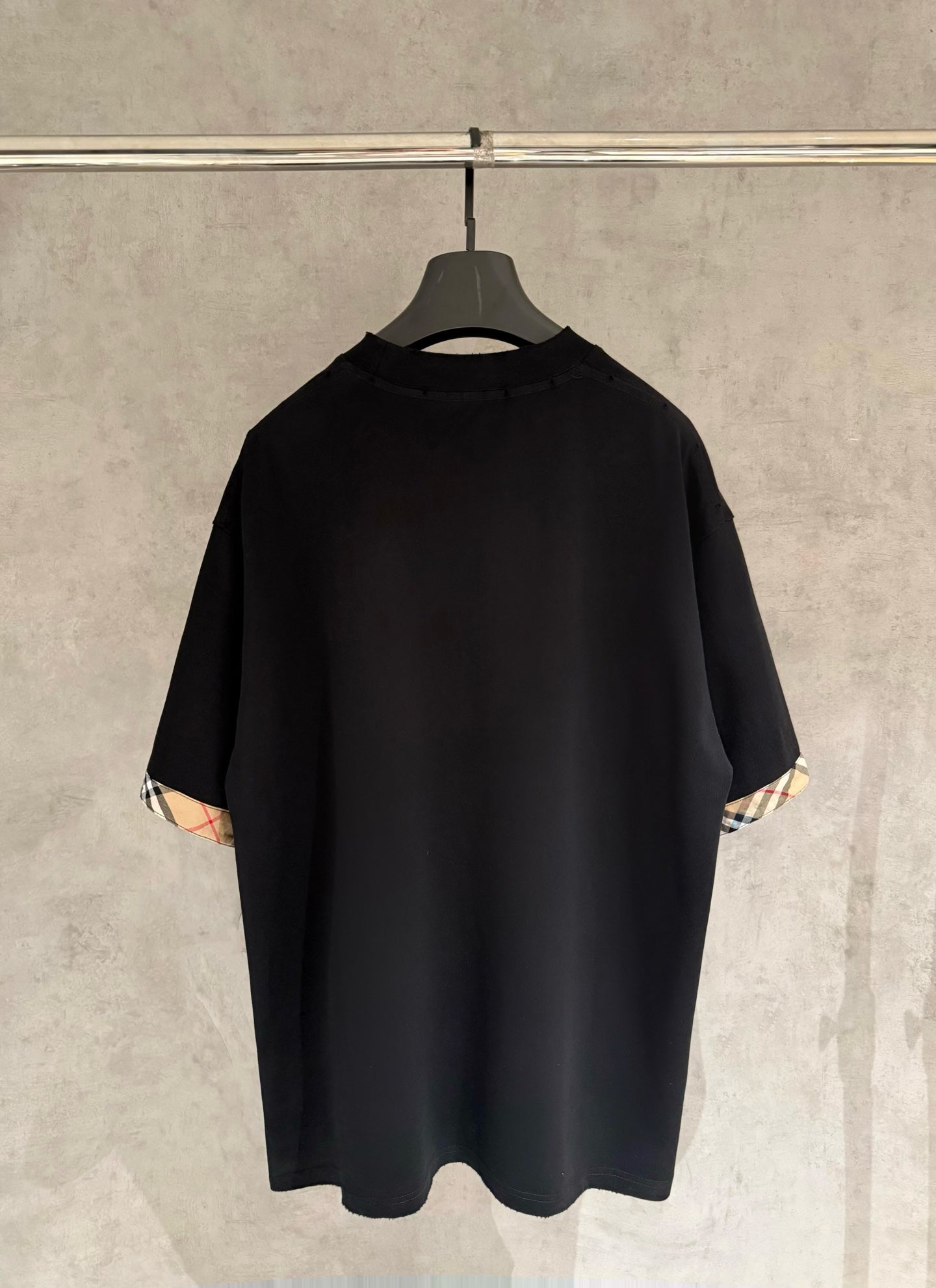 Black short-sleeve crewneck T-shirt, back view, with check-trim cuffs